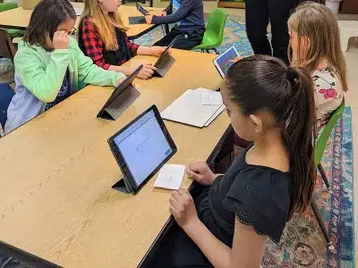 Elementary kids completing projects on tablets